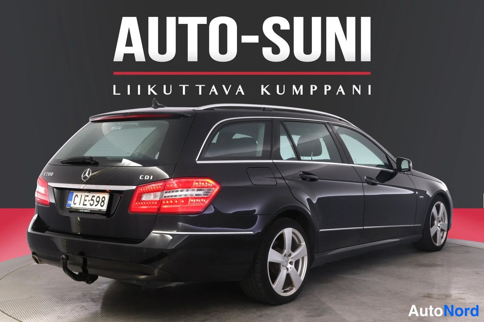 Takaviisto: Mercedes-Benz E 300 CDI -farmarin takakulma tummansinisellä maalilla, rekisteritunnus.