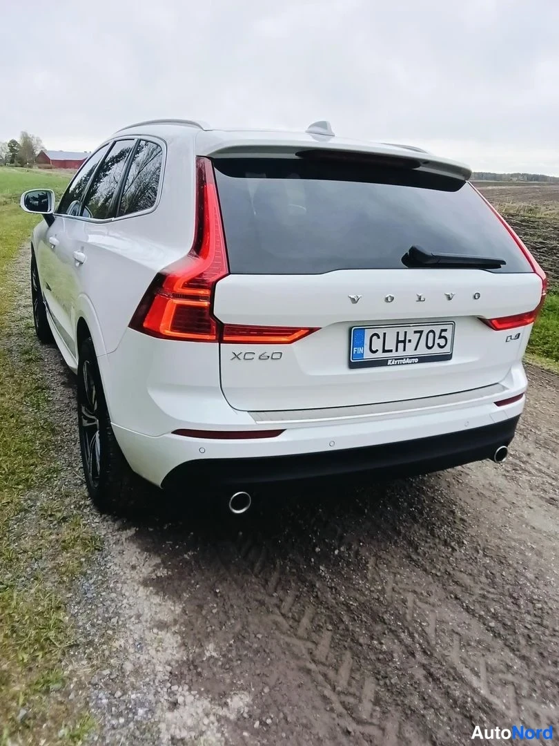 Takaviisto: Valkoinen Volvo XC60 takaa päin, XC60-tunnus ja rekisterikilpi näkyvät takanupeleineen.
