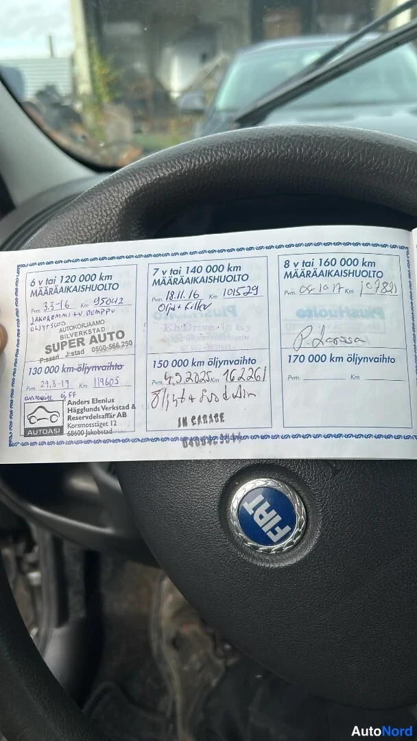 Muu: Huoltokirjan sivu Fiat-ohjauspyörän edessä: huoltomerkinnät 6–8 vuodelle, mm. SUPER AUTO- ja Autolle Oy -leimat.