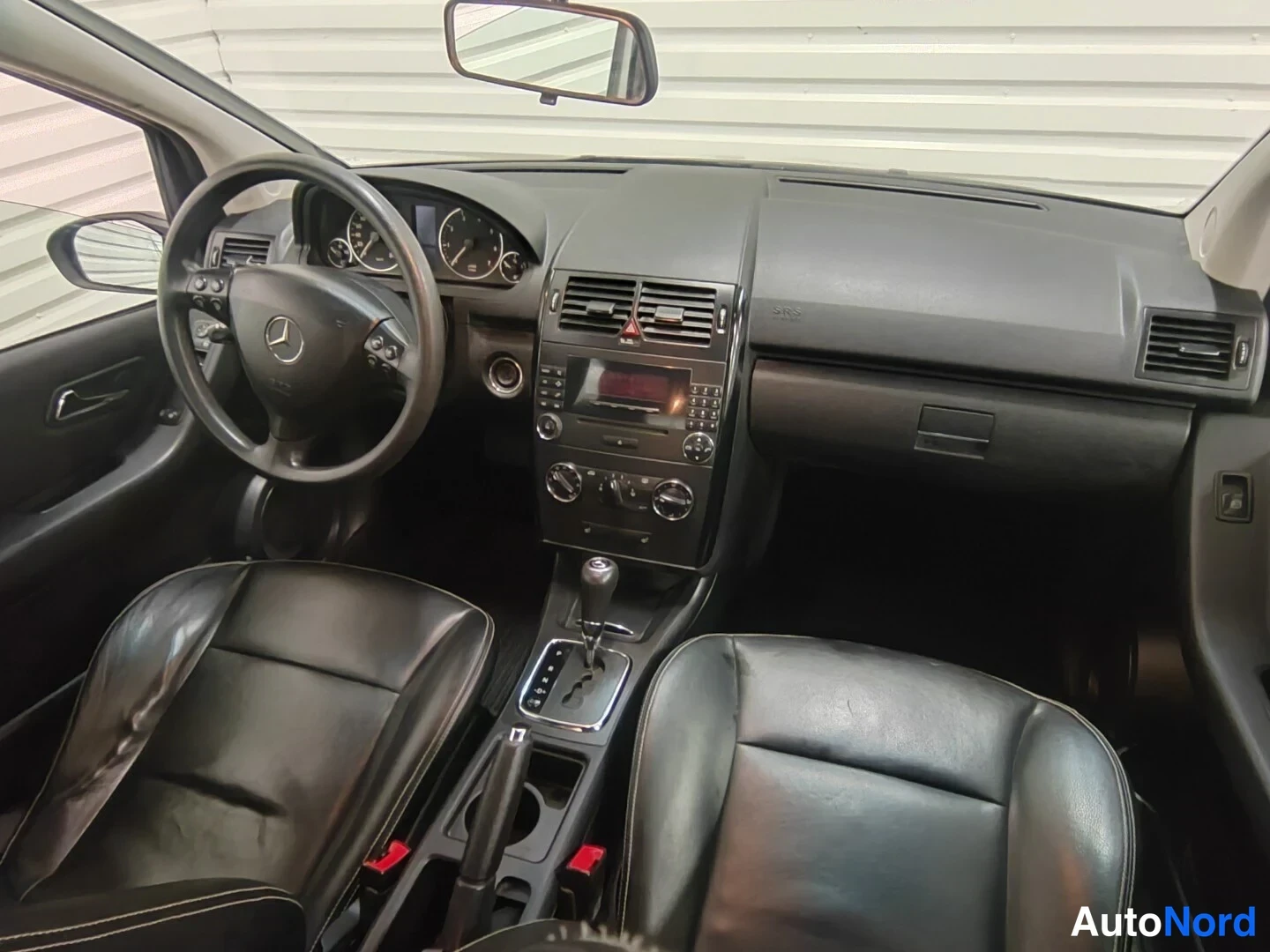 Yksityiskohta: Mercedes-Benz A 150 2006: kojelauta ja etuistuimet mustaa nahkaa.