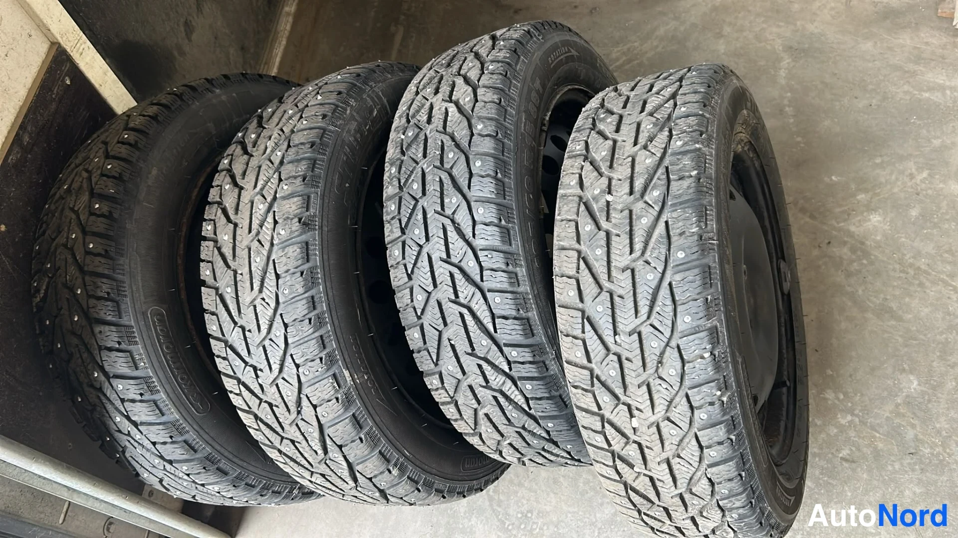 Muu: Neljä nastarengasta riviin aseteltuna betonilattialla.