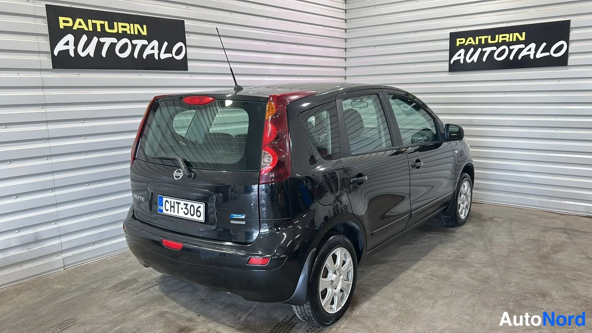 Takaviisto: Musta Nissan Note takaapikulmasta, rekisterikilpi näkyvissä.