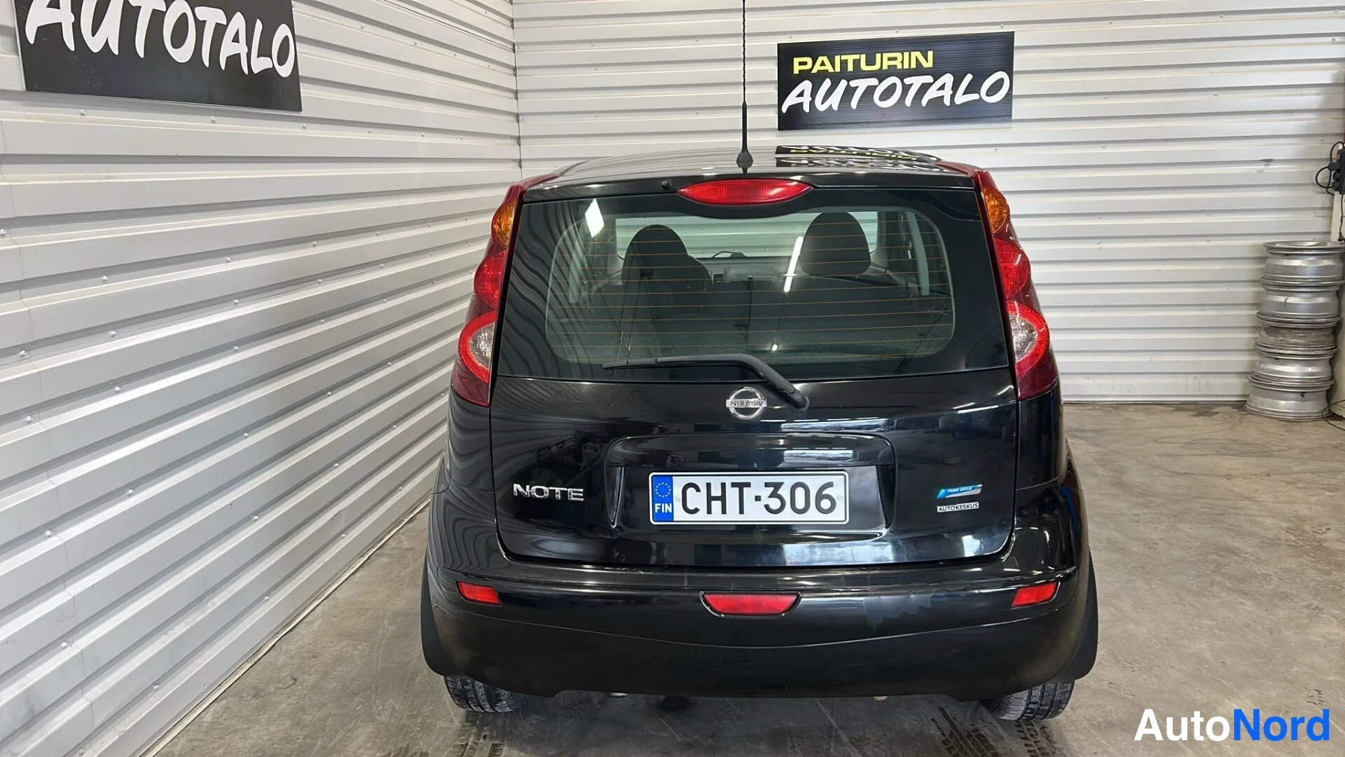 Takaa: Musta Nissan Note suoraan takaa, NOTE-merkintä ja rekisterikilpi.