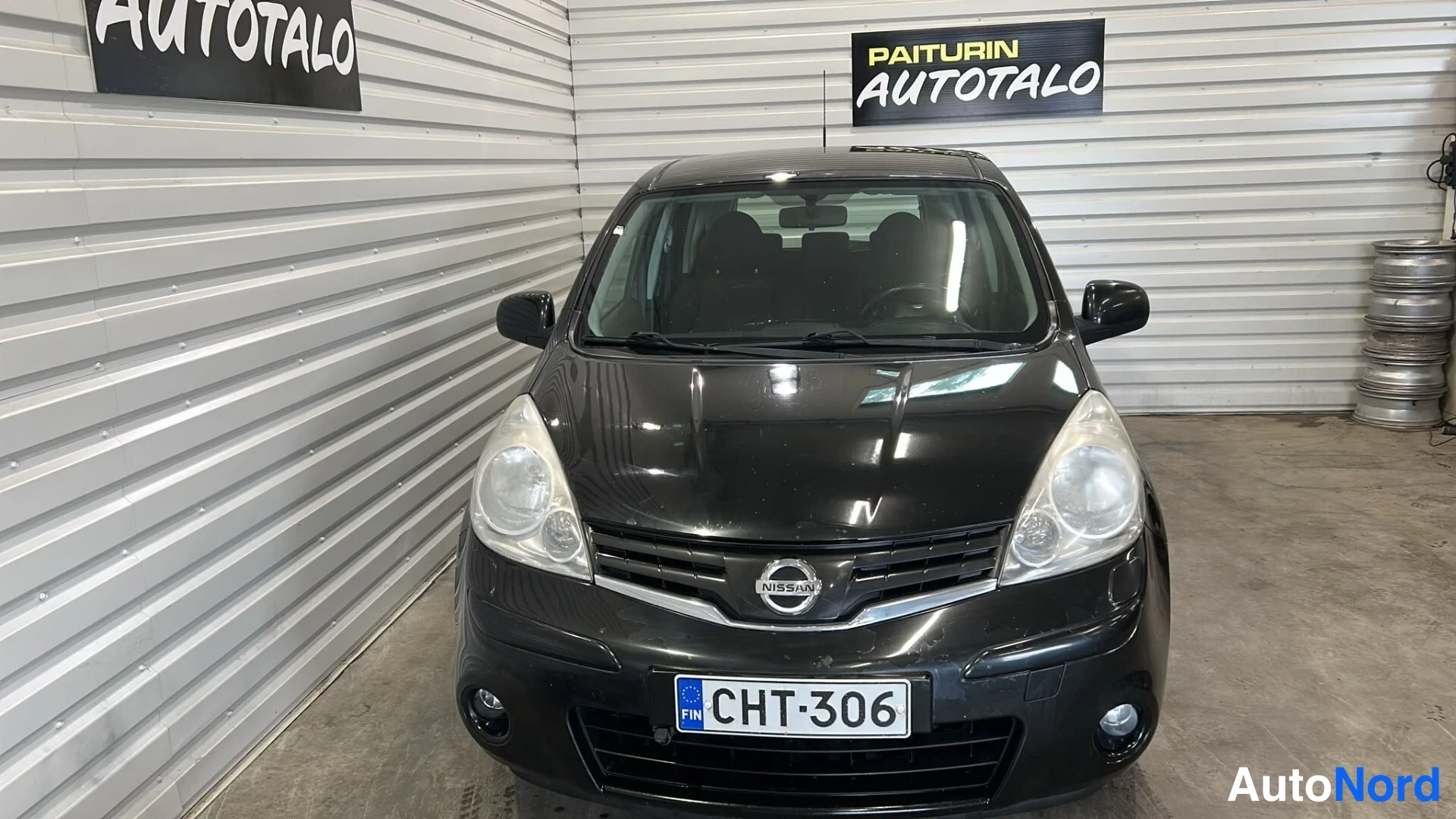 Edestä: Mustan Nissan Noten etuosa suoraan edestä, rekisteri.