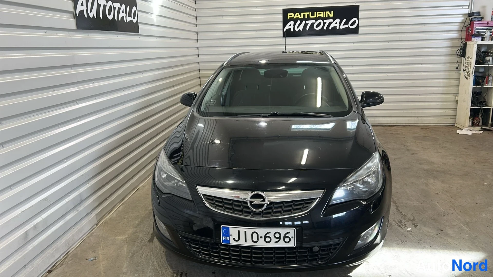 Edestä: Mustan auton etuosan suora kuva rekisterikilpi J10-696.