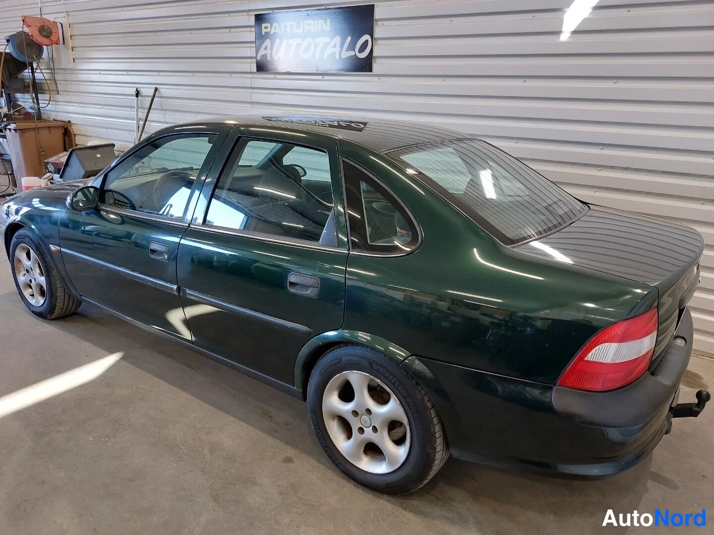 Takaviisto: Tummenvihreä Opel Vectra -sedan takaviistosta oikealta, takavalo ja kylki näkyvät.