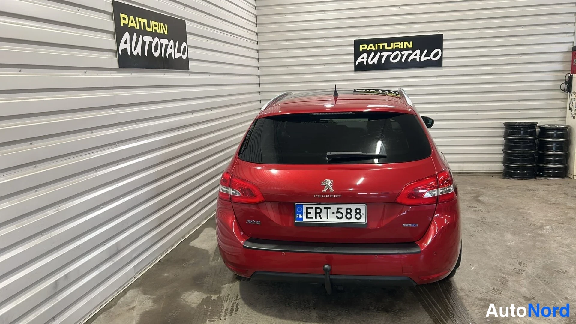 Takaa: Punainen farmariauto suoraan takaa sisätiloissa, rekisterikilpi.