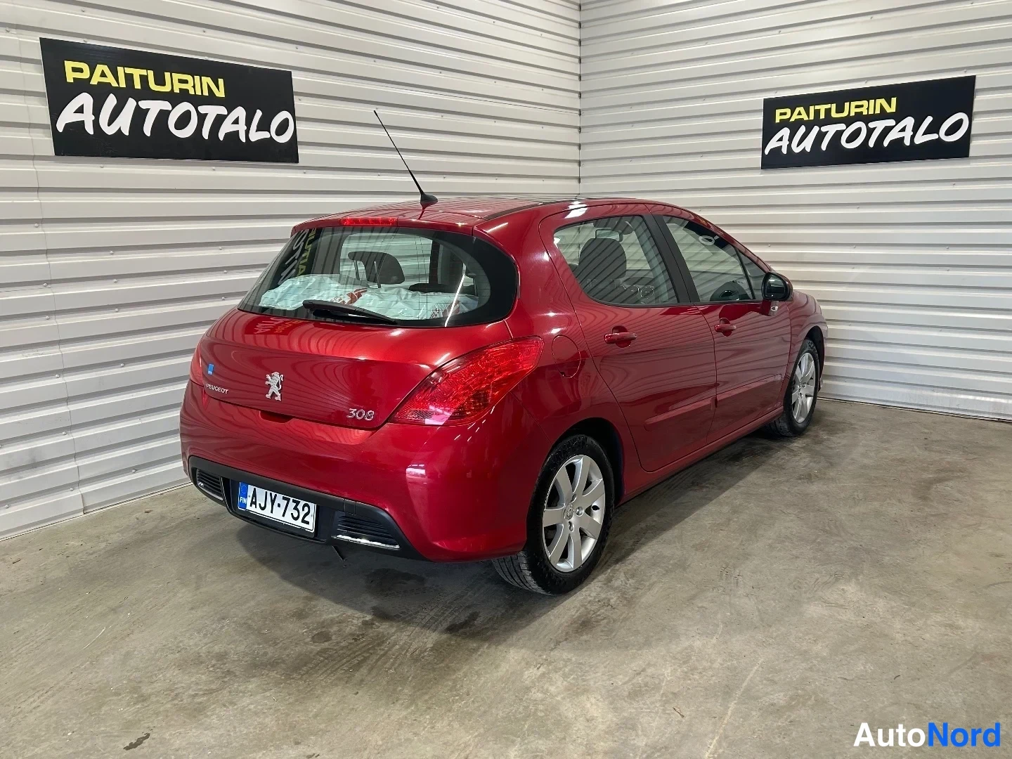 Takaviisto: Punainen Peugeot 308 takaa viistosti vasemmalta; rekisterikilpi ja mallimerkintä 308 näkyvät.