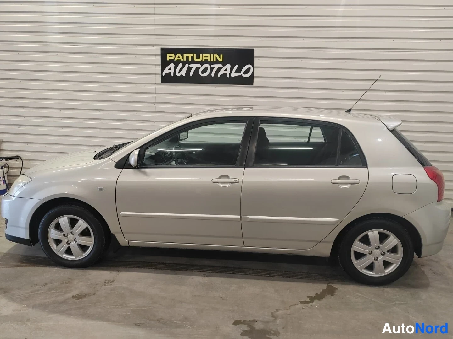 Etuviisto, nokka vasemmalle: Toyota Corolla -auton sivukuva autotallissa.