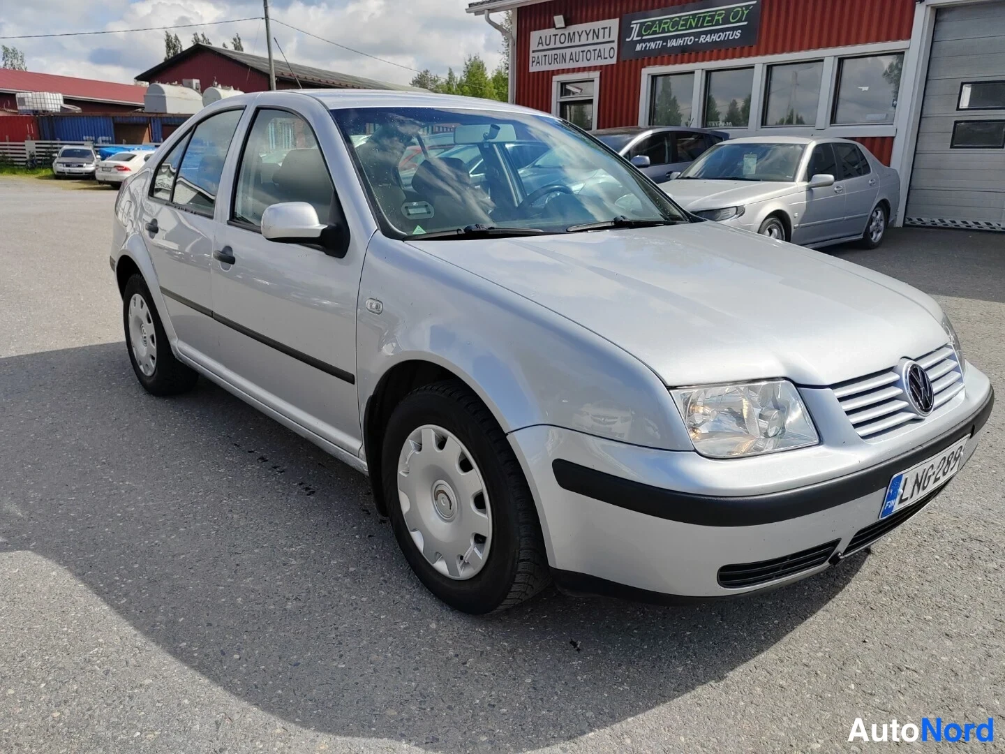 Etuviisto, nokka oikealle: Hopeanharmaa Volkswagen Bora -sedan kolme neljäsosaa edestä oikealta kuvattuna, kylki ja etuosa näkyvissä.