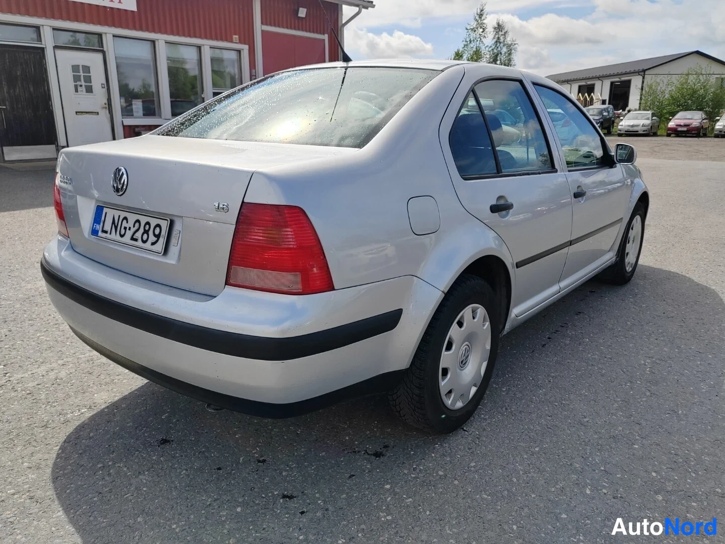 Takaviisto: Hopeanharmaa Volkswagen Bora -sedan takaosalta oikealta kuvattuna, rekisterikilpi.