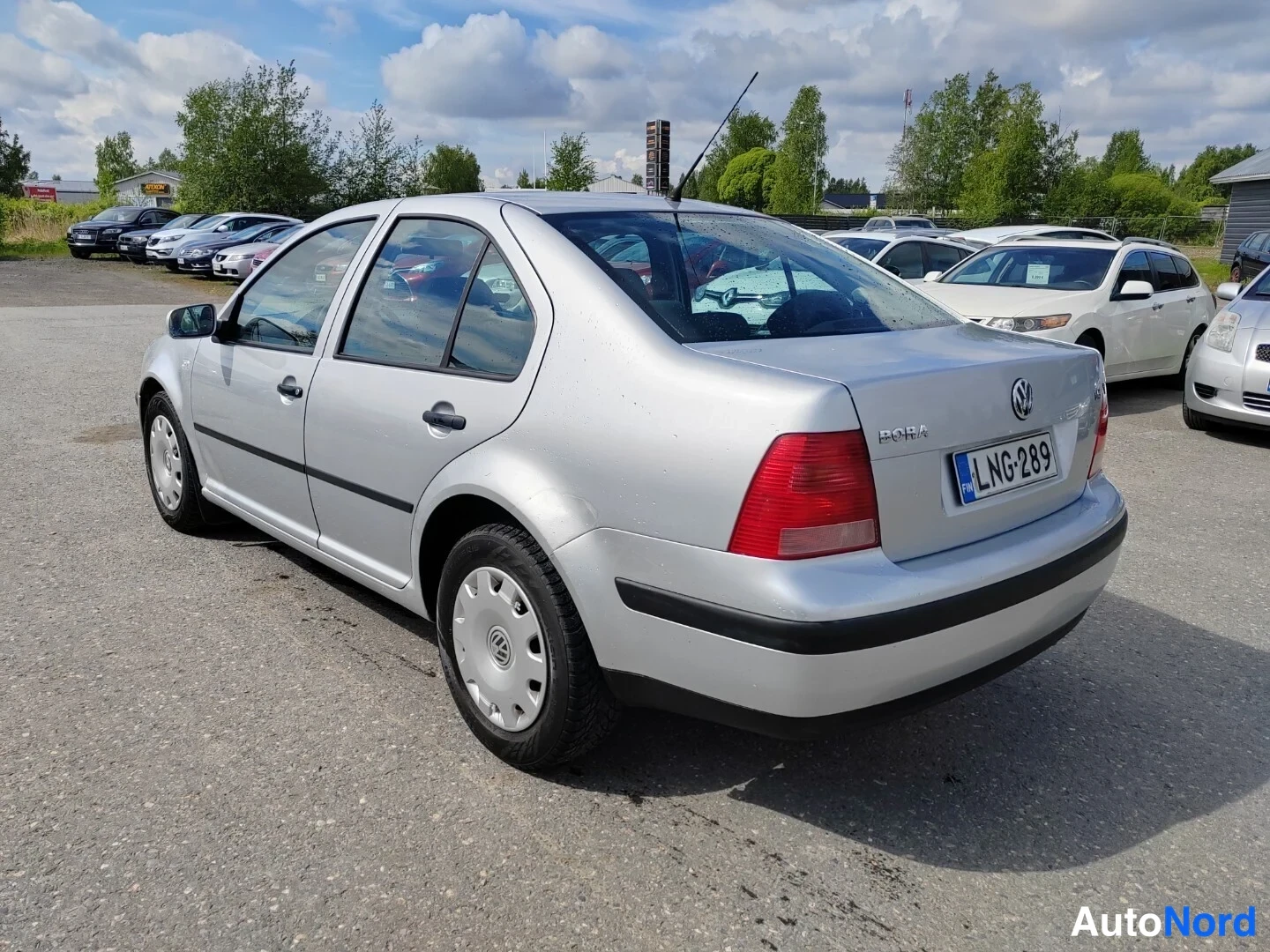 Takaviisto: Hopeanharmaa Volkswagen Bora -sedan takaosalta vasemmalta kuvattuna, takaponttooni tekstillä BORA ja rekisterikilpi.