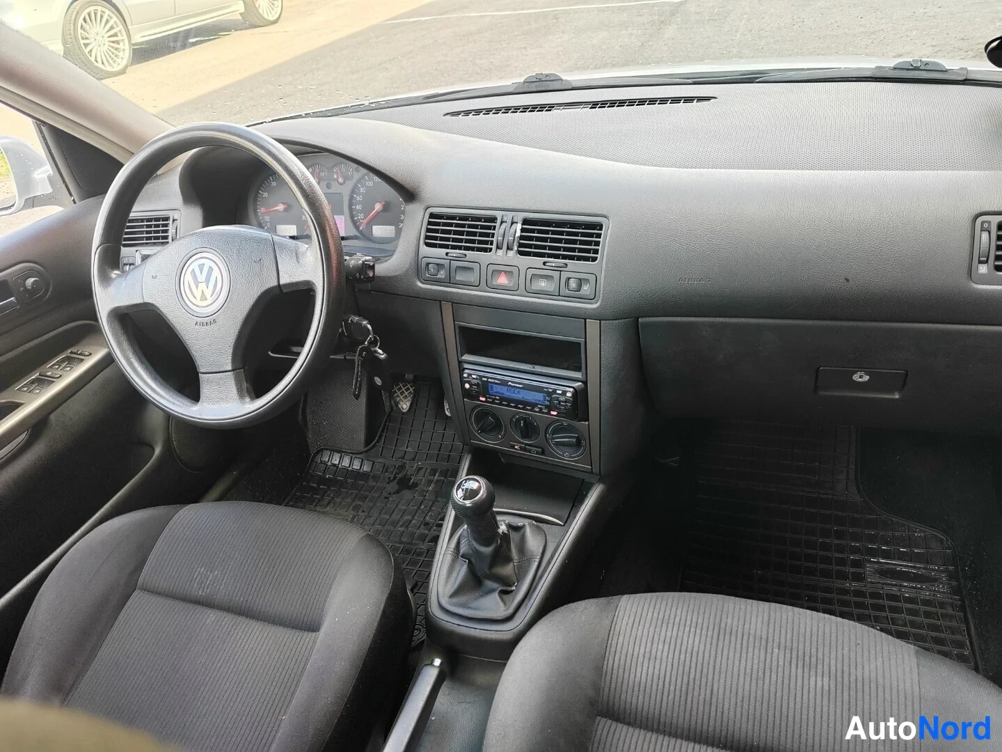 Muu: Auton etusija kuljettajan puolelta: Volkswagen-ohjauspyörä, mittaristo, manuaalivaihtoheinä, radio ja tumma verhoilu.