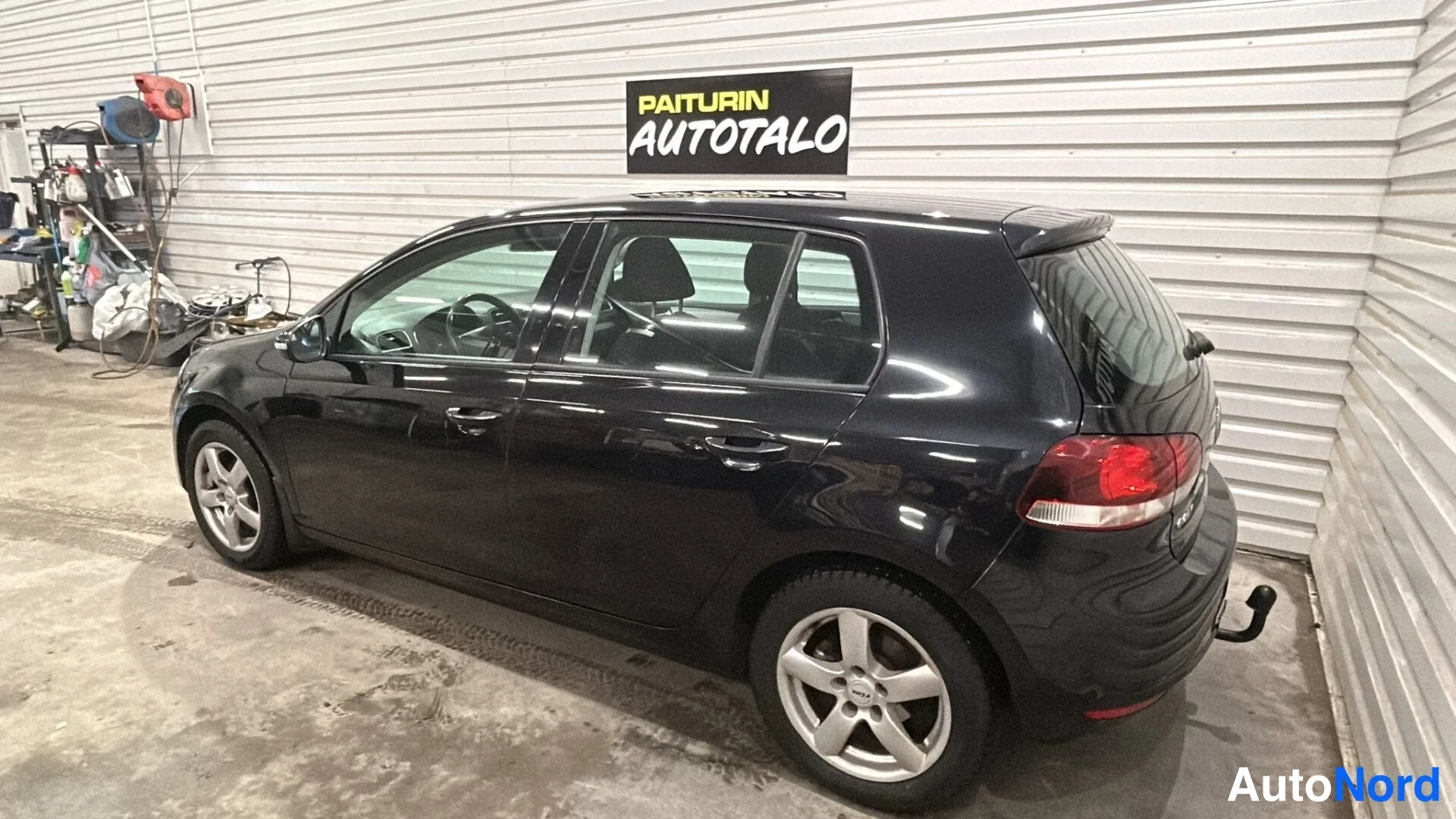 Takaviisto: Mustan Volkswagen Golfin takakolmannes sivulta oikealta, perävaunun rakennettu.