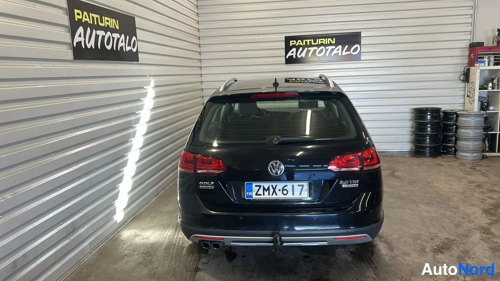 Takaa: Mustan farmariauton takanäkymä, rekisteritunnus, kyltissä teksti GOLF ALLTRACK