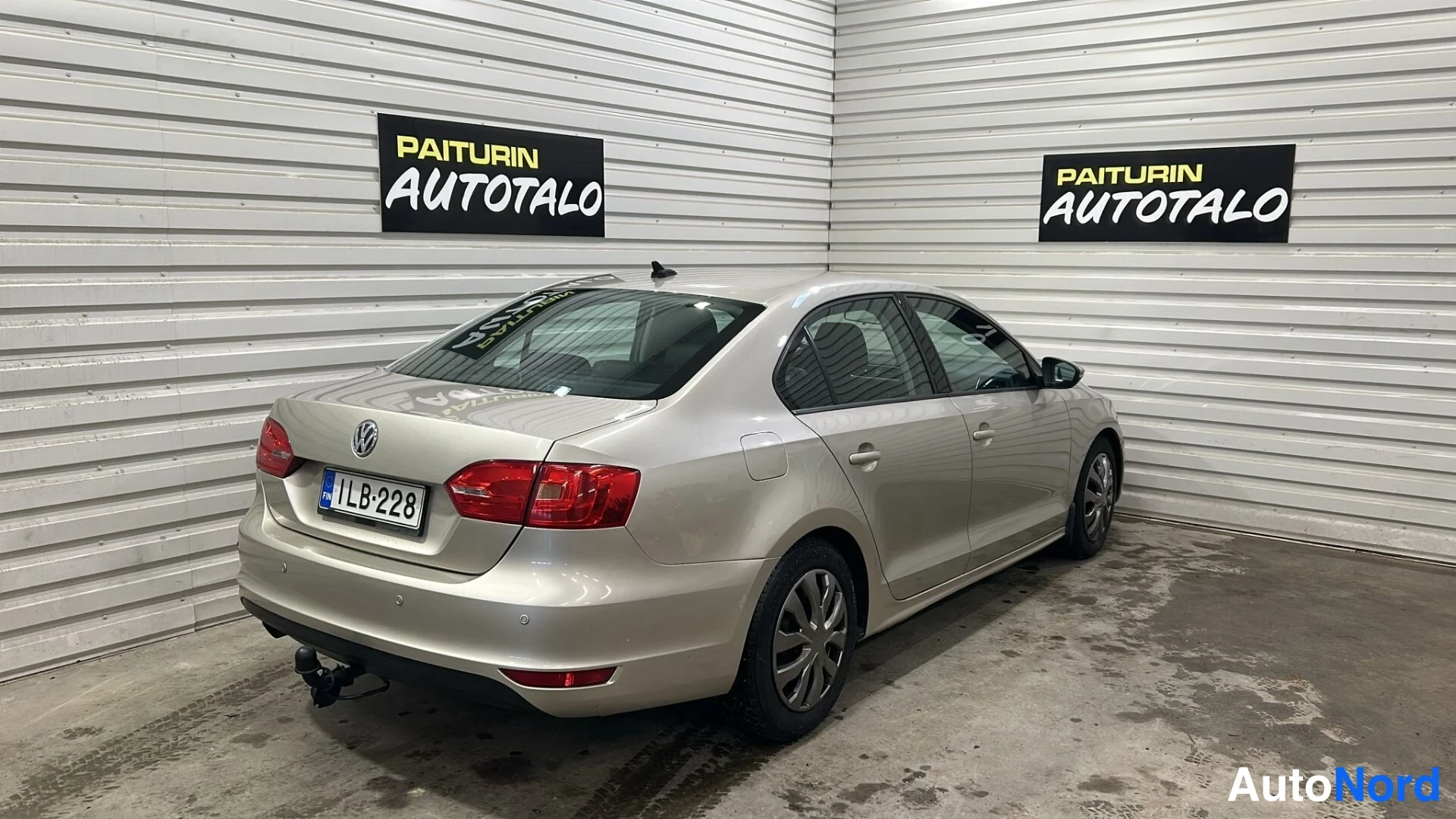 Takaviisto: Volkswagen Jetta -sedanin takakulma vasemmalta; rekisteritunnus ja vetokoukku näkyvät.