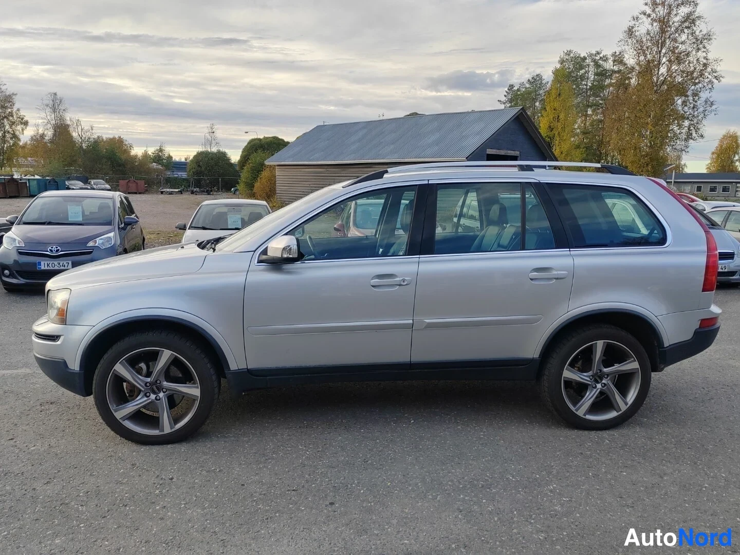 Sivulta: Volvo XC90:n sivukuva; hopeinen koripaneeli, viisi ovea ja hopeavanteet näkyvät.