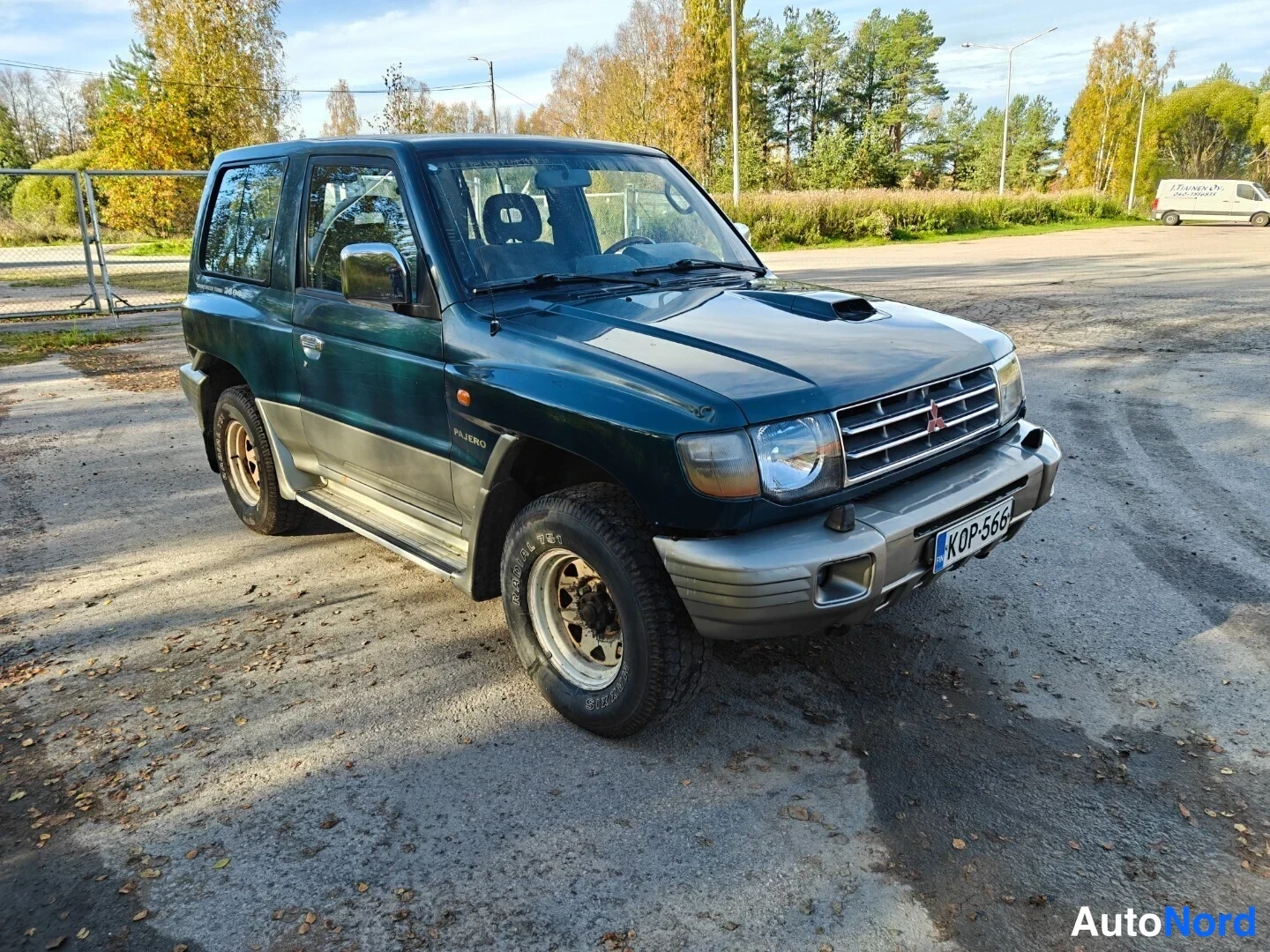 Etuviisto, nokka oikealle: Mitsubishi Pajero kolmesta neljäsosasta etuoikealle, konepellillä ilmanottoaukko, rekisteritunnus.