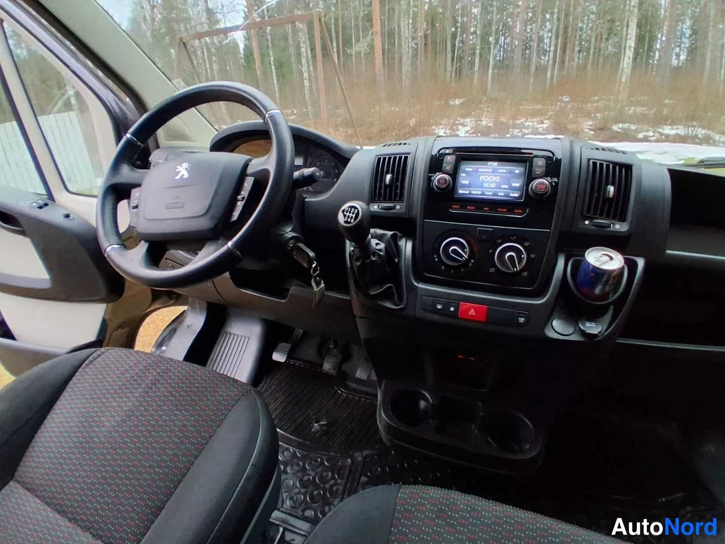 Muu: Ajo­paikan sisäkuva: ohjauspyörä Peugeot-logolla, käsivallevelinen vaihtaja, radio ja kojelaudan ilmastointisäätimet.