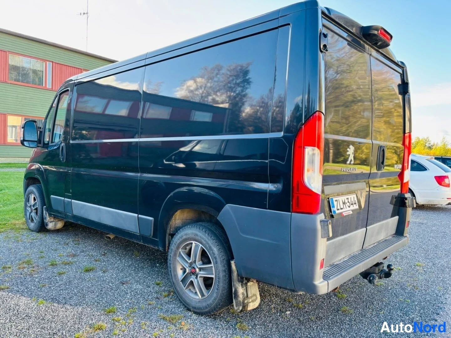 Takaviisto: Peugeot Boxer pakettiauto takaosa oikealle kääntyneenä, rekisterimerkki, Peugeot-merkki takaluukussa.