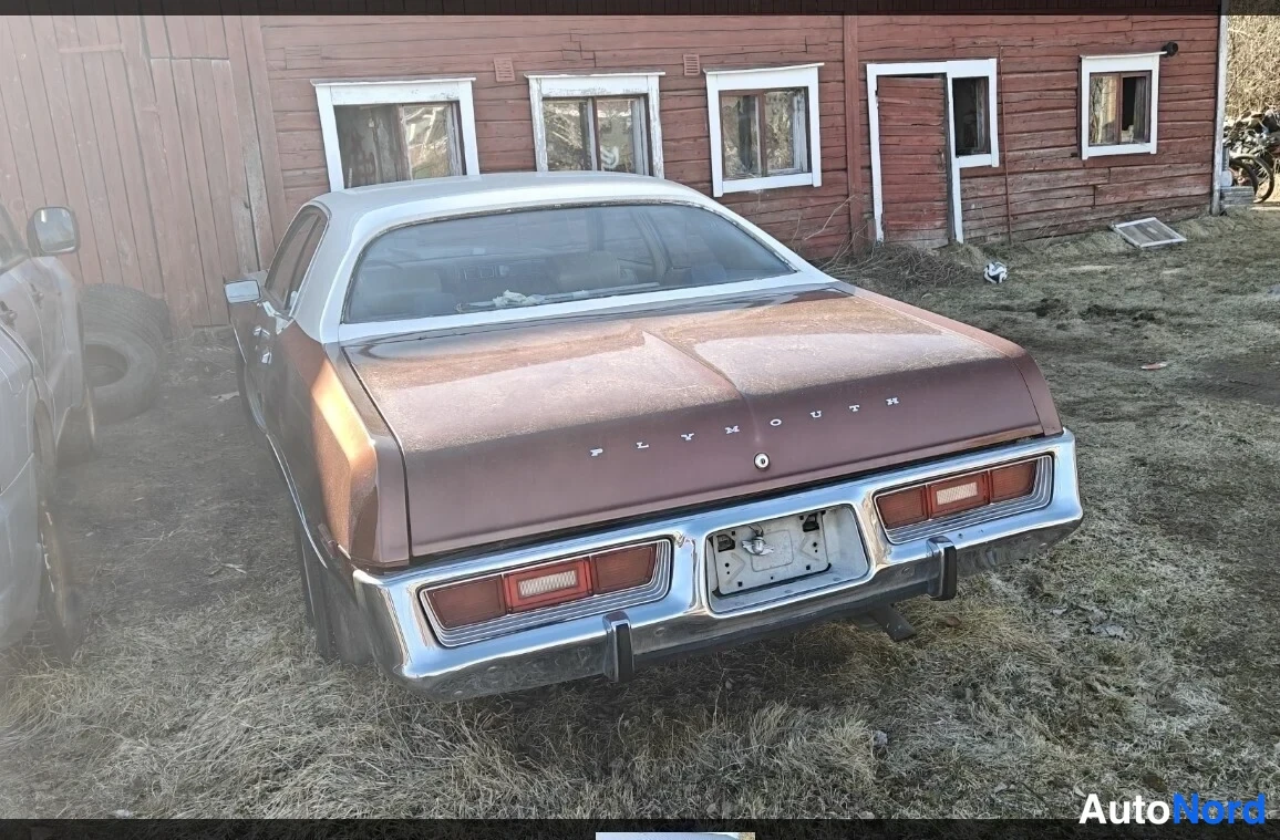 Takaviisto: Ruskean auton takakulmakuva: takaosaan kohotettu kansi, PLYMOUTH-teksti kannessa, punaiset takavalot ja kromipuskuri.