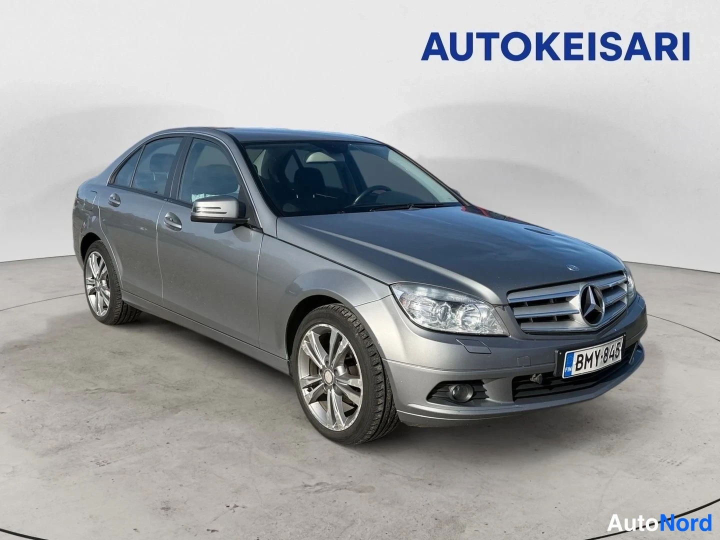 Etuviisto, nokka oikealle: Mercedes-Benz C-sarjan sedan etuokoliskuva oikealta, hopeanharmaa kori, rekisterikilpi.