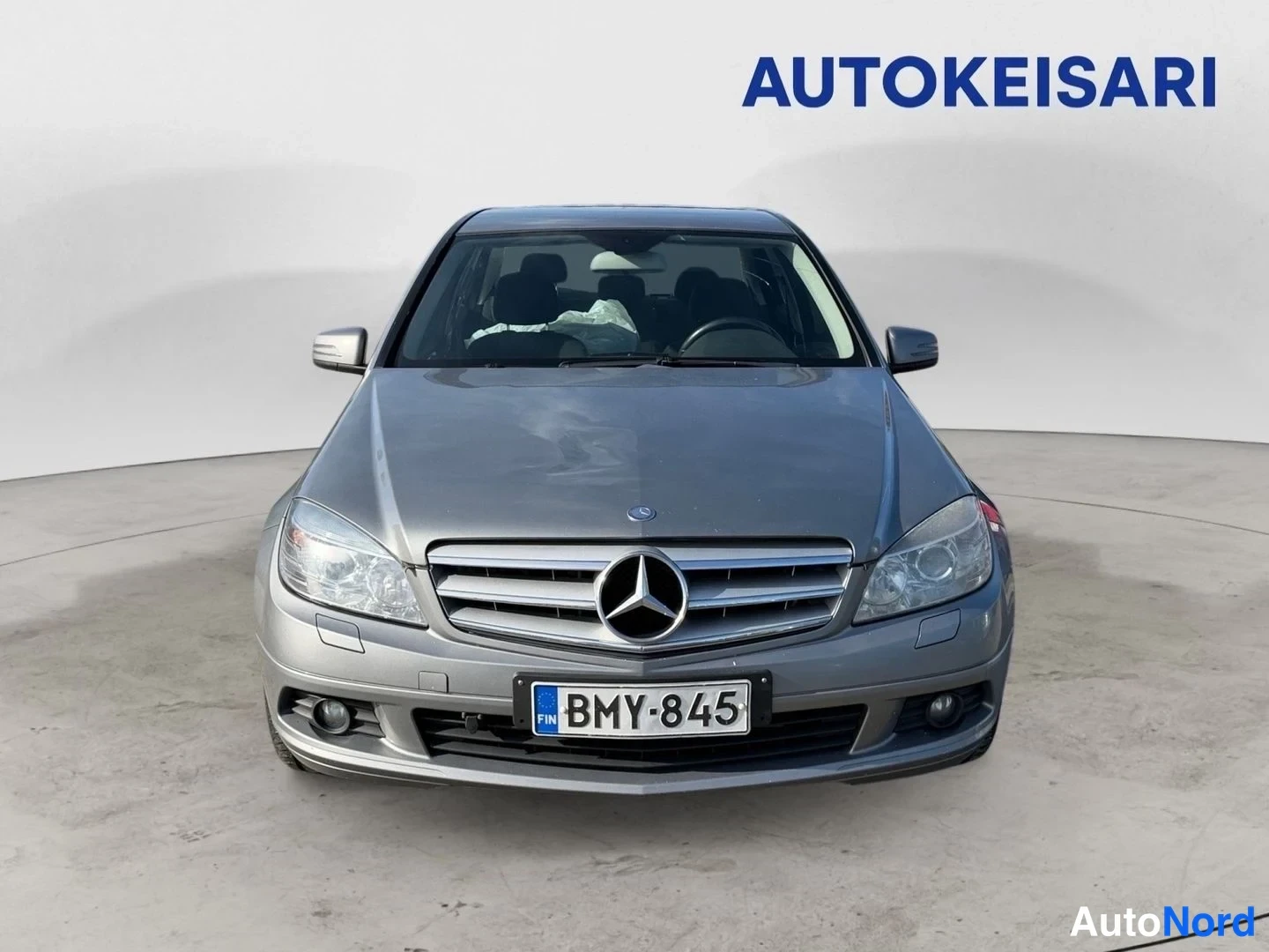Edestä: Mercedes-Benz C-sarjan sedan suora etukuva, hopeanharmaa kori, rekisterikilpi.