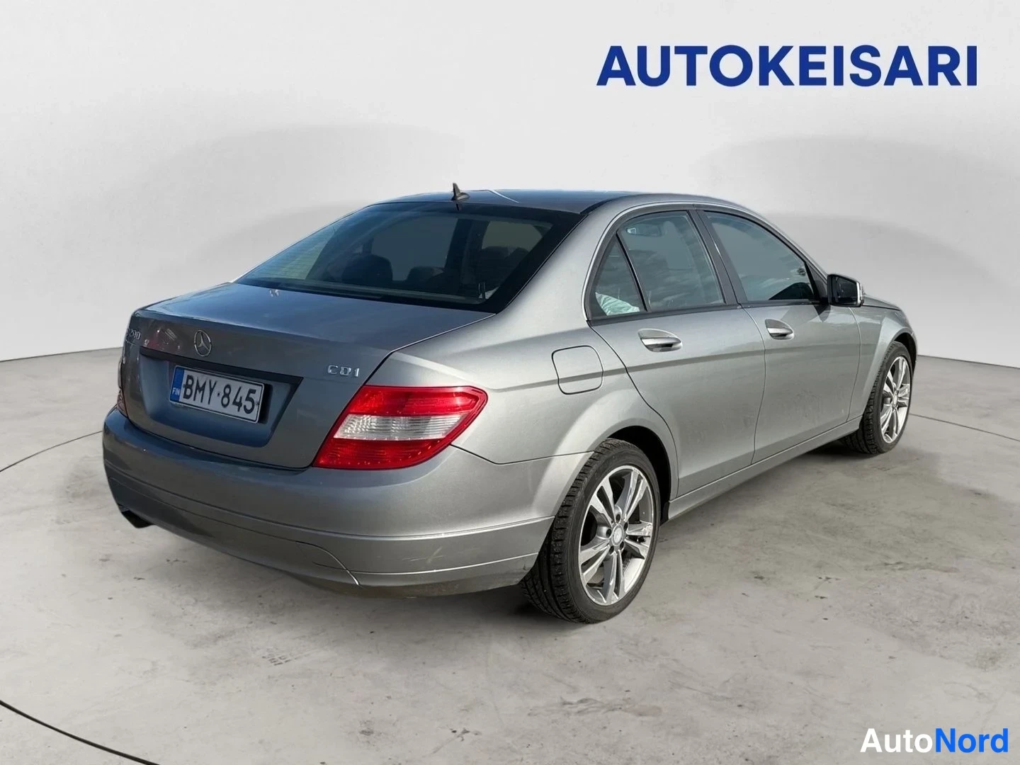 Takaviisto: Mercedes-Benz C-sedan takaviistokuva vasemmalta. Hopeanharmaa koripaneeli, kuvioitu kevytmetallivanteet, rekisterikilpi ja CDI-teksti tavaratilan kannessa näkyv