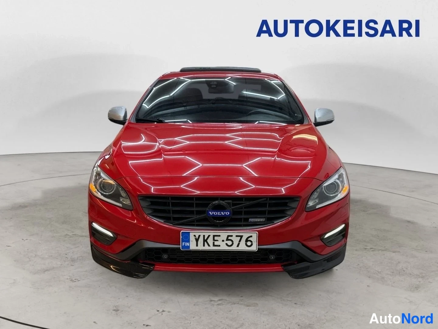 Edestä: Punaisen Volvo S60 -sedanin suora etukuva; Volvo-maski, sumavalot ja rekisteritunnus näkyvissä.