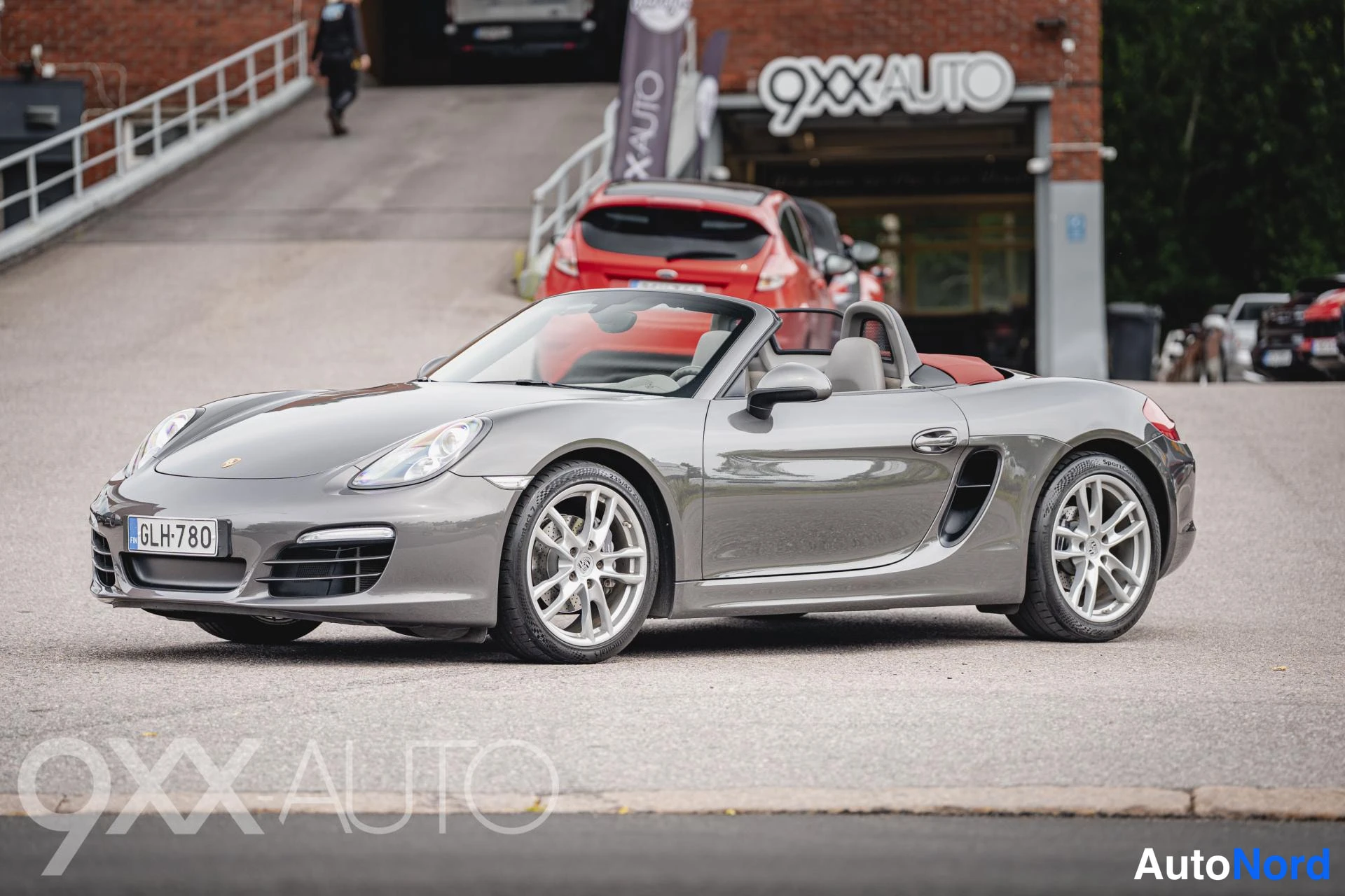 Etuviisto, nokka vasemmalle: Porsche Boxster avomalli kuvattu etu kolmasosan kuvakulmasta, keula vasemmalla; katto avattu, rekisteri.