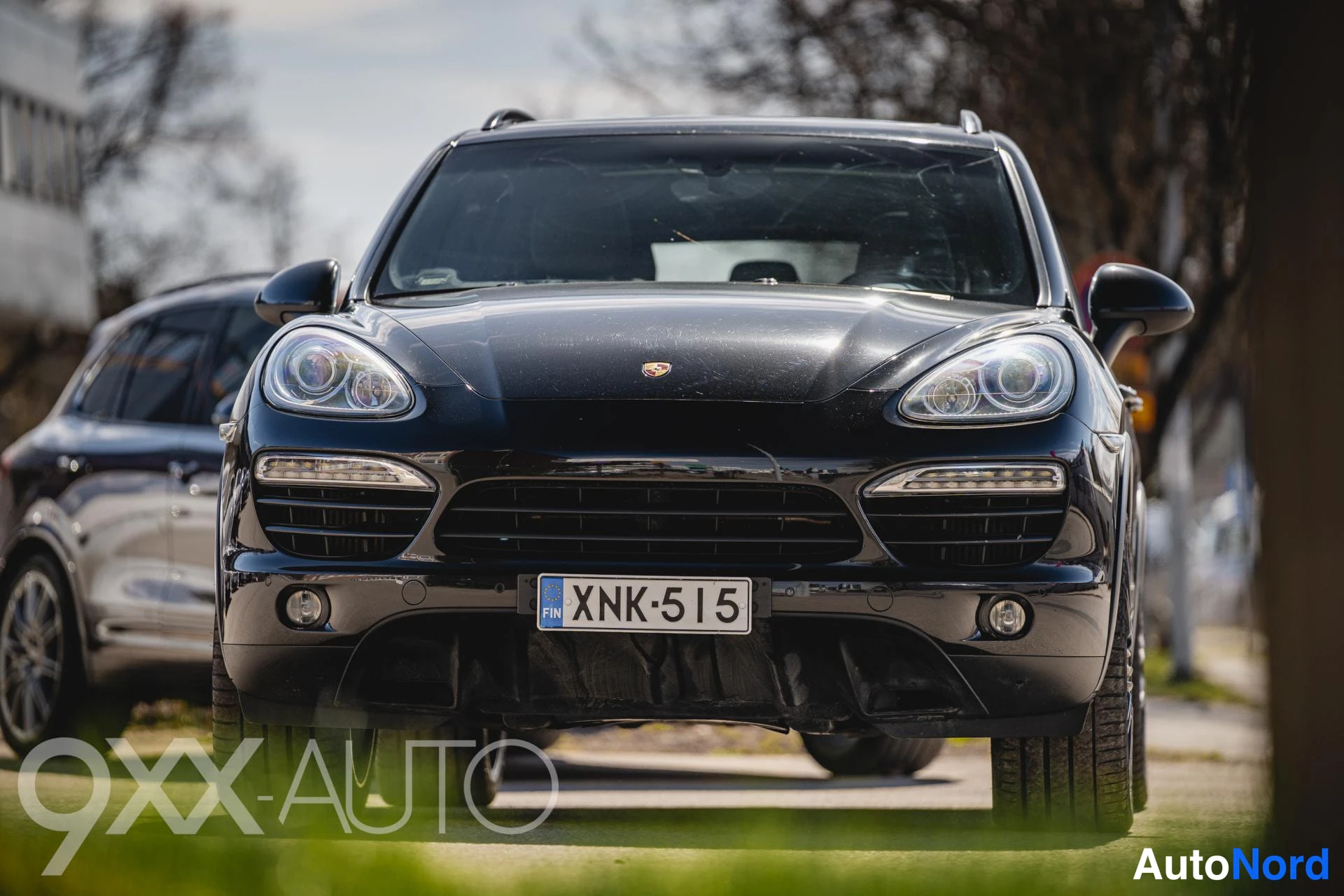Edestä: Mustan Porsche-katumaasturin etupuoli suoraan edestä valokuvattuna; rekisterikilpi.