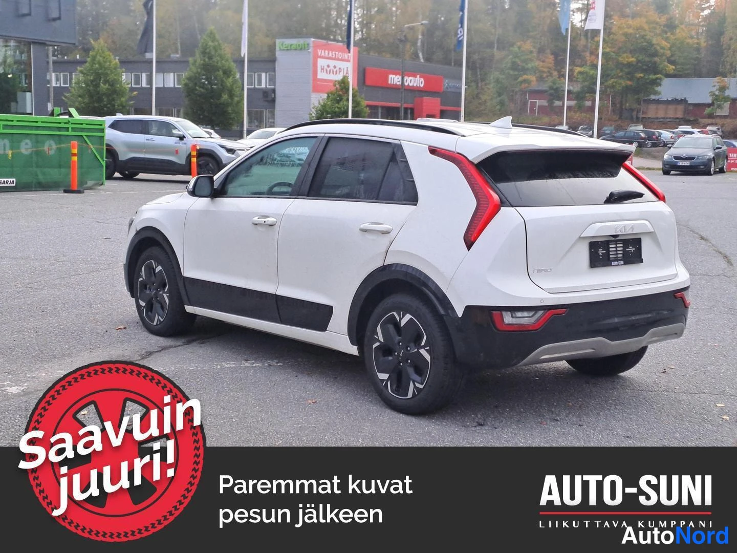 Takaviisto: Valkoinen Kia Niro kuvattu takaa vasemmalta kolmannelta neljäsosakulmalta parkkipihalla, takavalot ja takaosa näkyvissä.