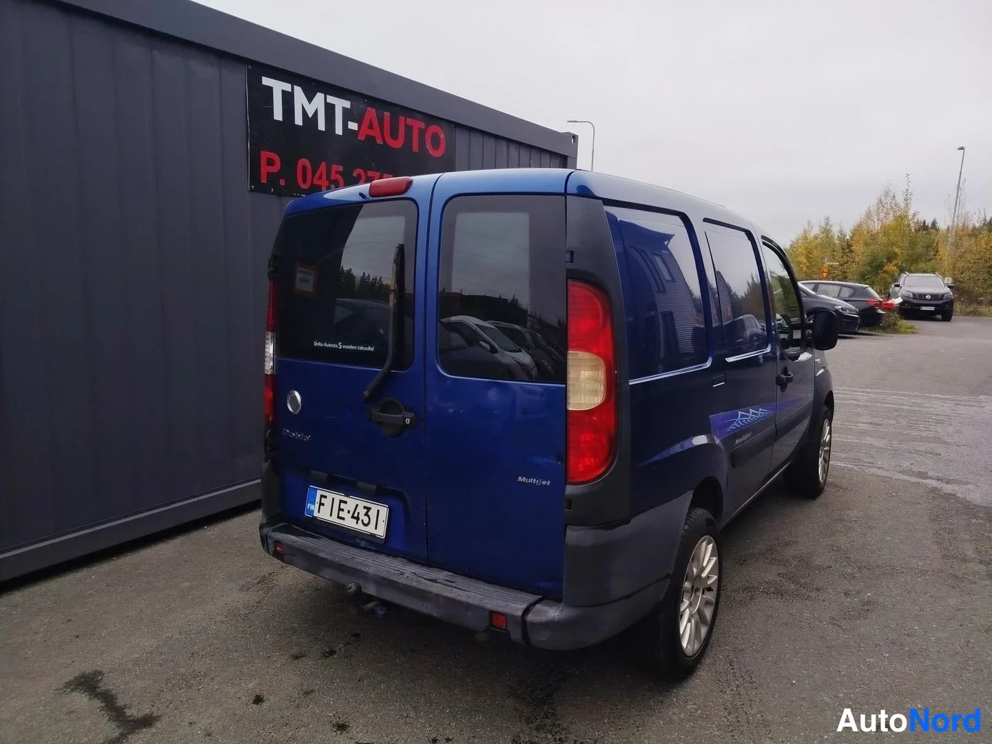 Takaviisto: Sinisen pakettiauton takaosa ja oikea kylki, rekisteritunnus.