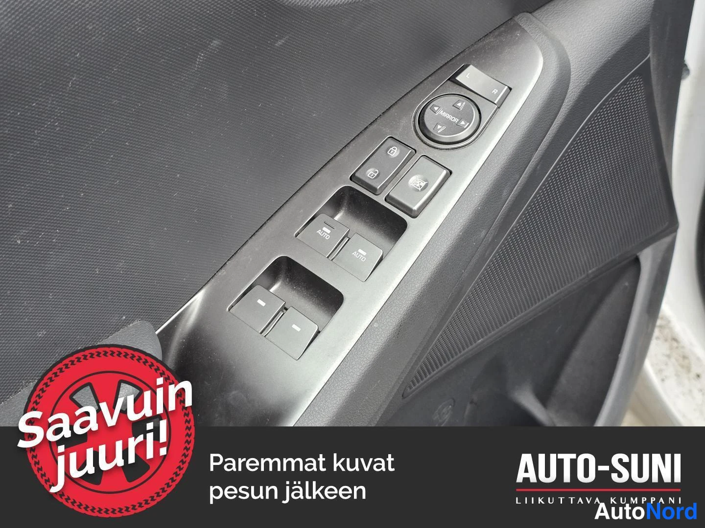 Sivulta: Sisäkuva oven paneelin painikkeista: peilinsäädin MIRROR-merkinnällä, lukituksen aukaisu- ja lukituspainikkeet sekä neljä ikkunonnostinta, joista kahdessa AUTO-