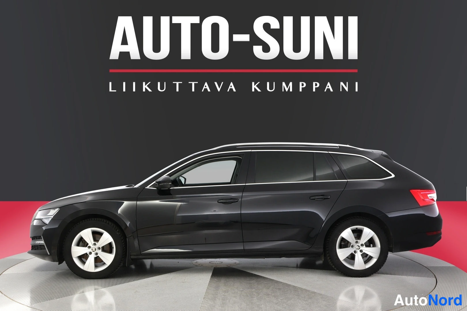 Sivulta: Side profile of a black station wagon on a turntable. The grille and rear are not visible. Silver alloy wheels are present.