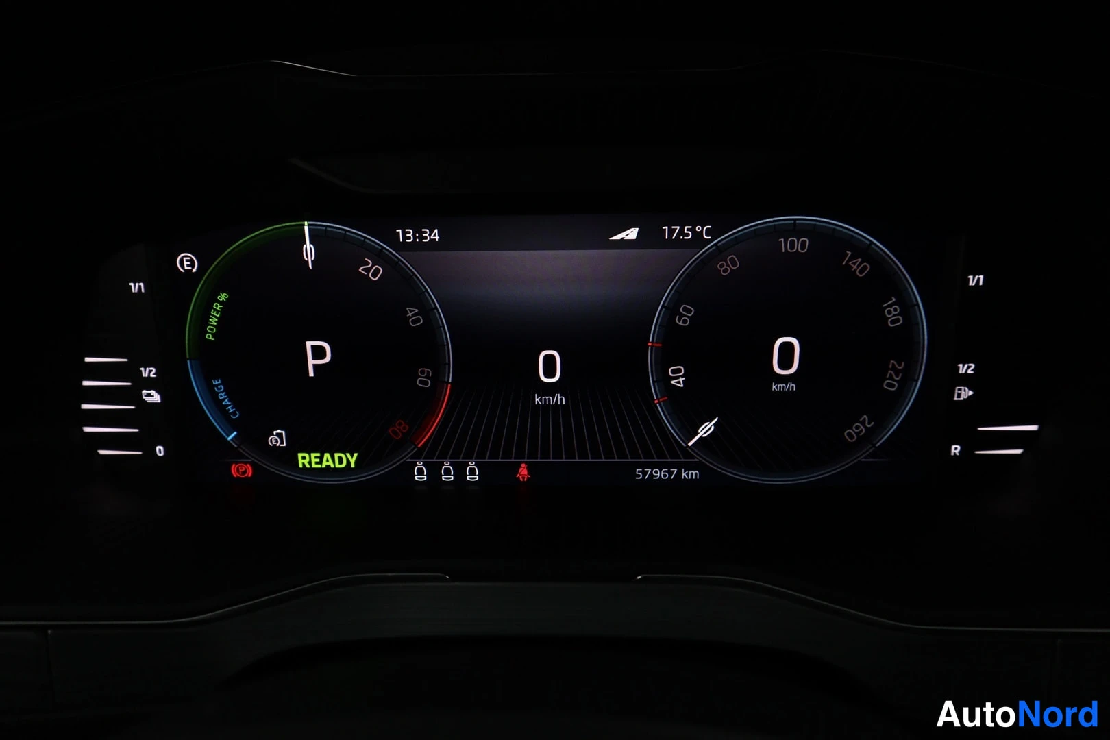 Ohjaamo: Digitaalinen mittaristo, jossa on virtamittari, nopeusmittari (0 km/h) ja lukemat: kellonaika 13:34, ulkolämpötila 17.5°C, kulkumatka 57967 km sekä READY-tilan