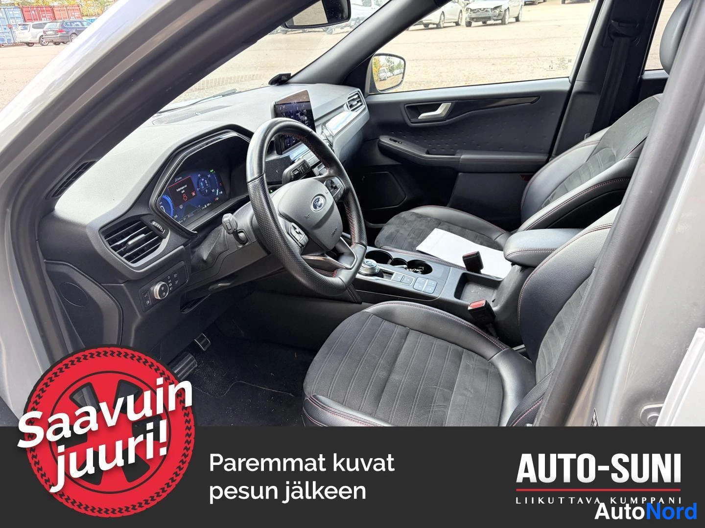 Etuistuimet: Black cabin interior showing steering wheel, dashboard and front seats