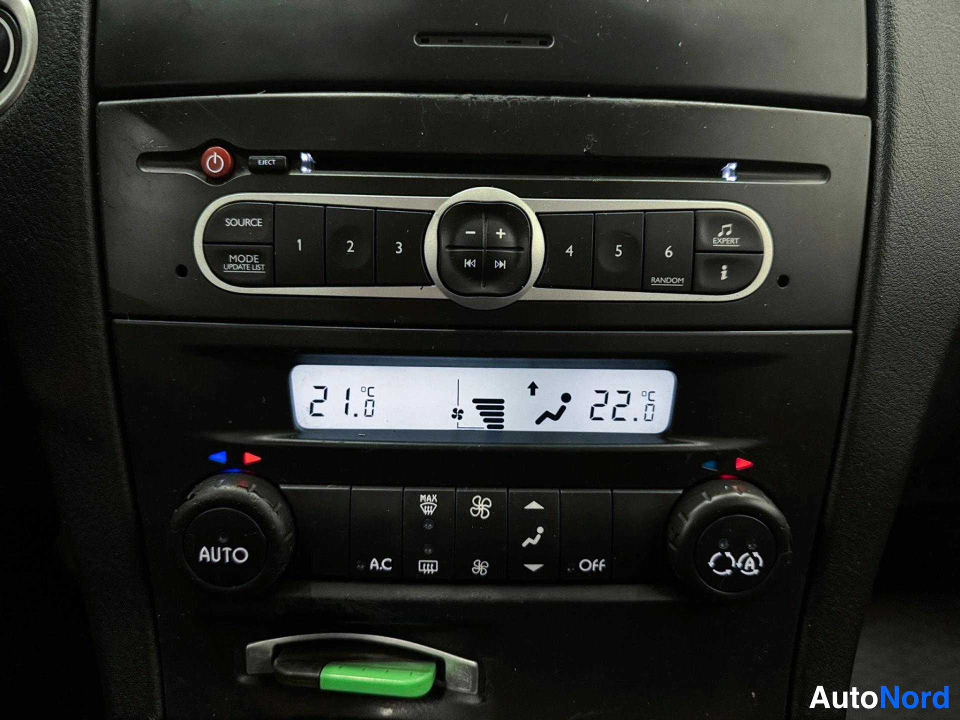 Muu: Keski konsolin radio- ja CD-yksikkö numeroiduilla näppäimillä 1–6, lämpötilanäyttö 21,0 °C ja 22,0 °C sekä AUTO-, A/C- ja Off-merkinnoilla varustetut automaatti