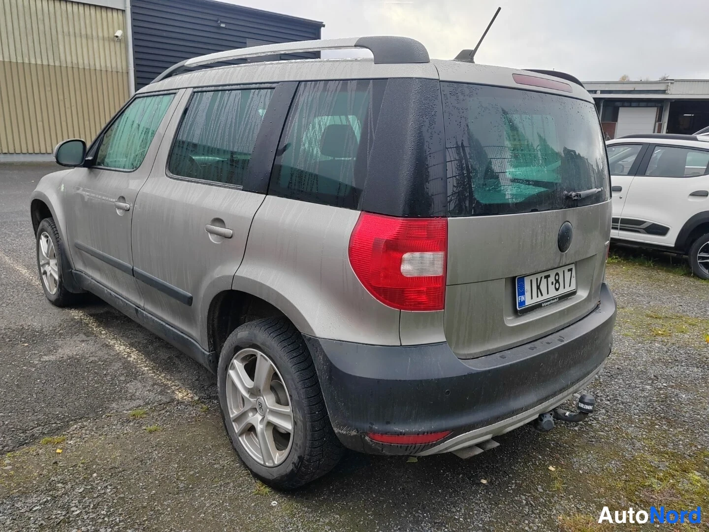Takaviisto: Rear three-quarter view of a dusty metallic beige SUV showing rear tail lights, boot lid and rear bumper