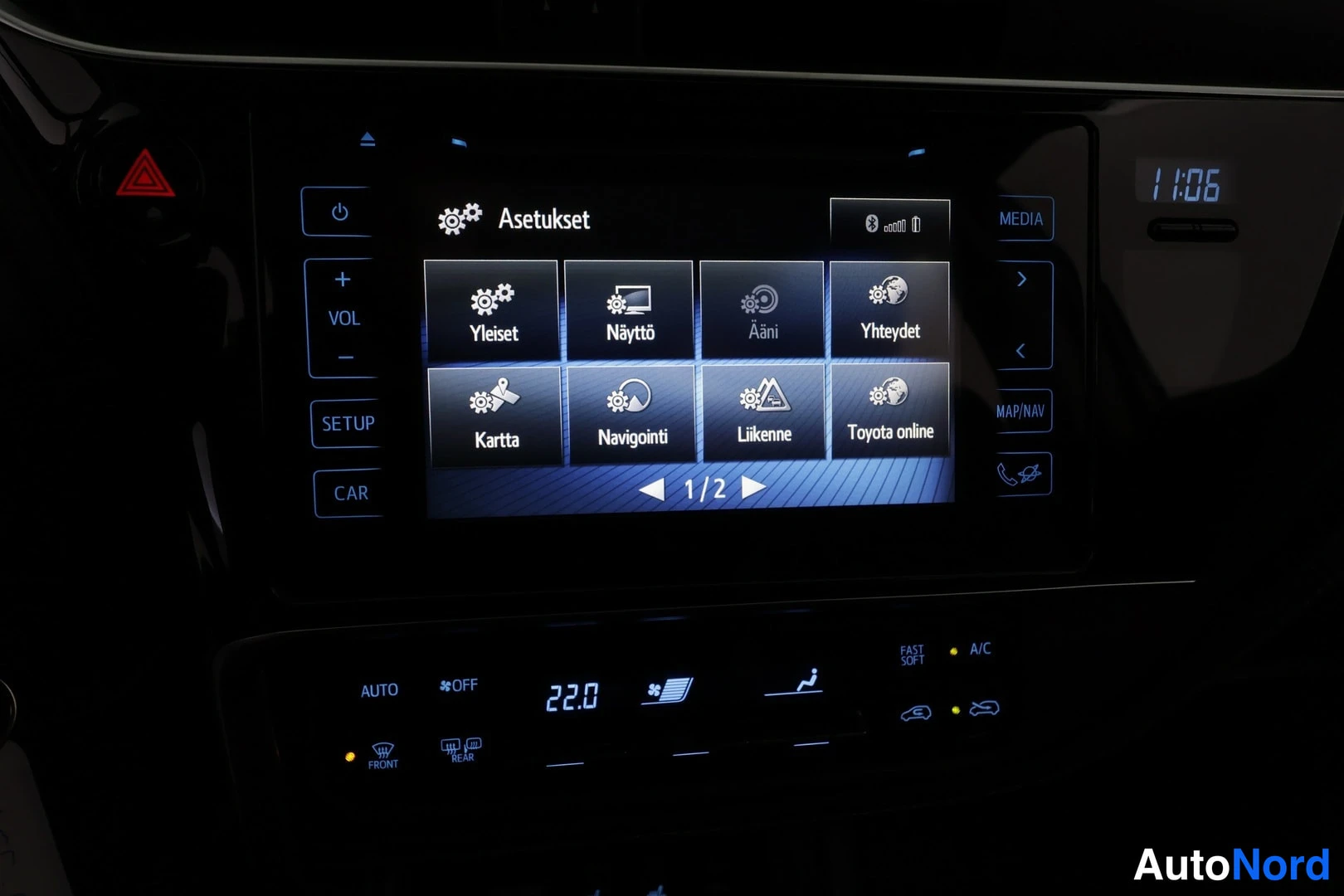 Edestä: Keskikonsolin infotainment-näyttö Asetukset-valikossa: Yleiset, Näyttö, Ääni, Yhteydet, Kartta, Navigointi, Liikenne ja Toyota online; alla ilmastointipaneeli n