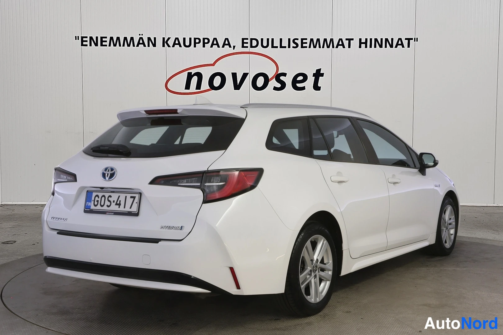 Takaviisto: Valkoinen farmariauto takakulmasta vasemmalta, rekisteritunnus.