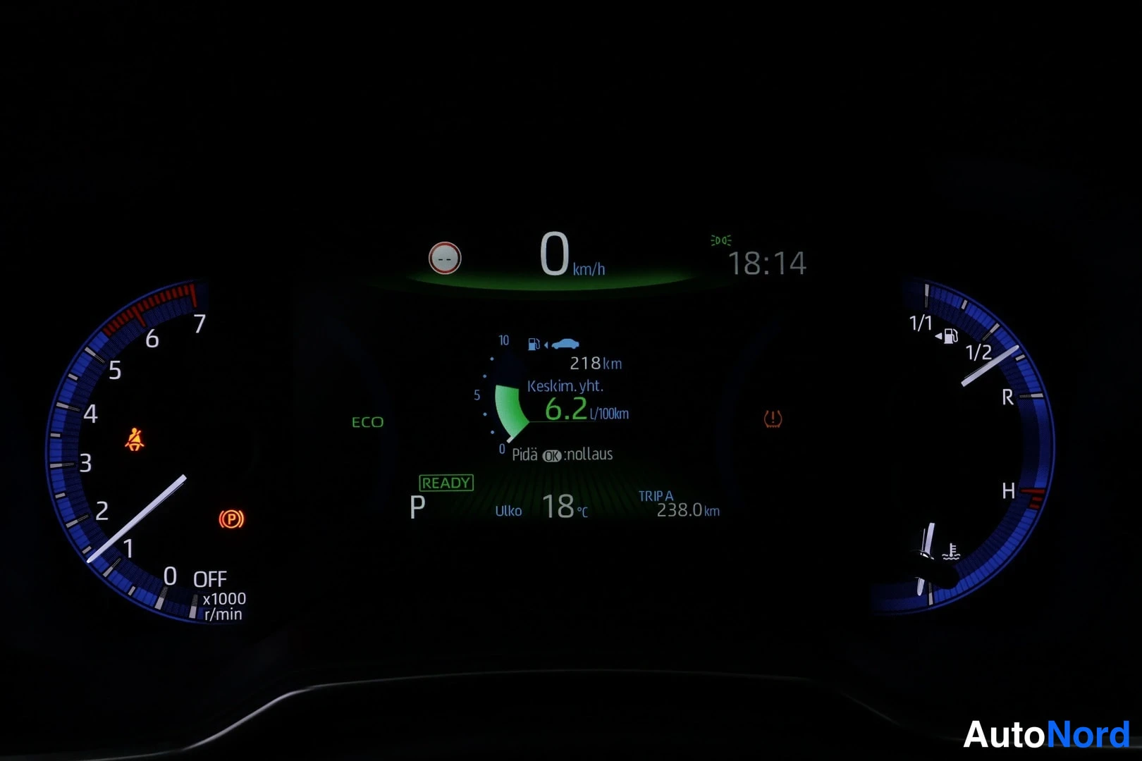 Muu: Kojelaudan mittariston lähikuva: nopeus 0 km/h, hybridimerkintä READY, kulutus 6,2 l/100 km, kellonaika 18:14, ulkolämpötila 18 °C, TRIP A 238,0 km ja vaihde P.