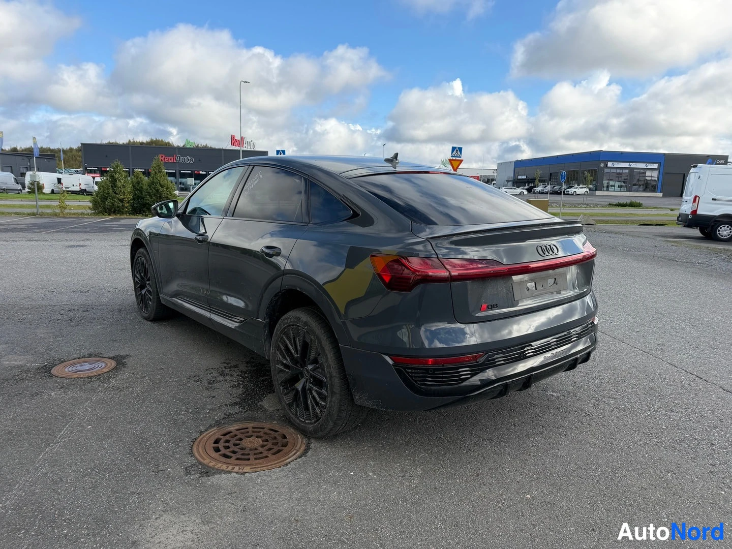 Takaa: Graysävyinen SUV kuvasi takaa, takana näkyvät takavalot ja takaluukku
