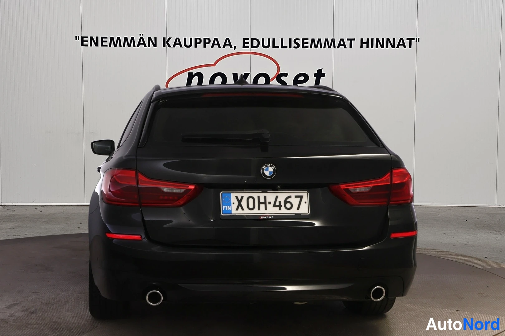 Takaa: Direct rear view of a black BMW station wagon with dual exhaust tips and license plate.