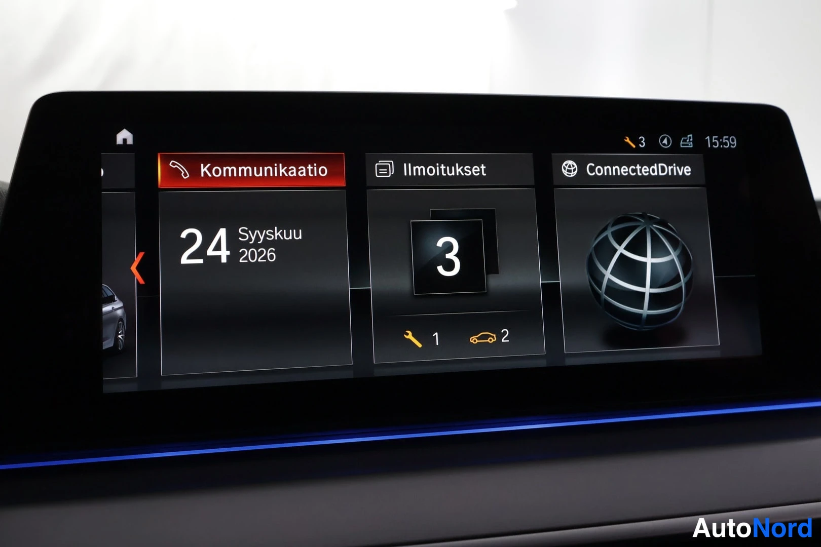 Yksityiskohta: Auton kosketusnäytön aloitusnäkymä, jossa valikot Kommunikaatio, Ilmoitukset ja ConnectedDrive sekä päivämäärä 24.9.2026 ja kello 15:59.
