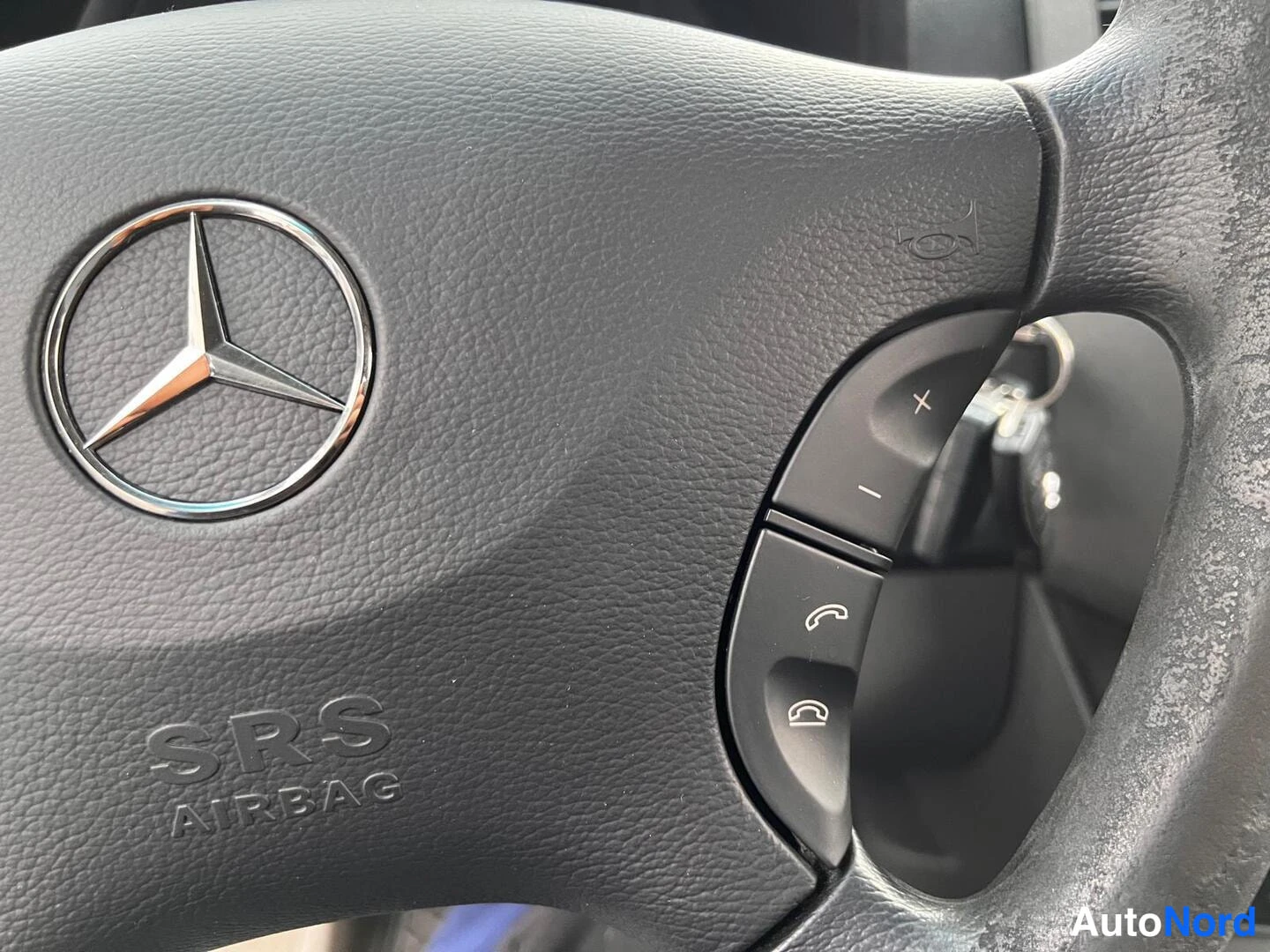 Muu: Ohjauspyörän keskusta, jossa Mercedes-tähti ja SRS AIRBAG-teksti, oikealla puhelin- ja äänenvoimakkuuspainikkeet.