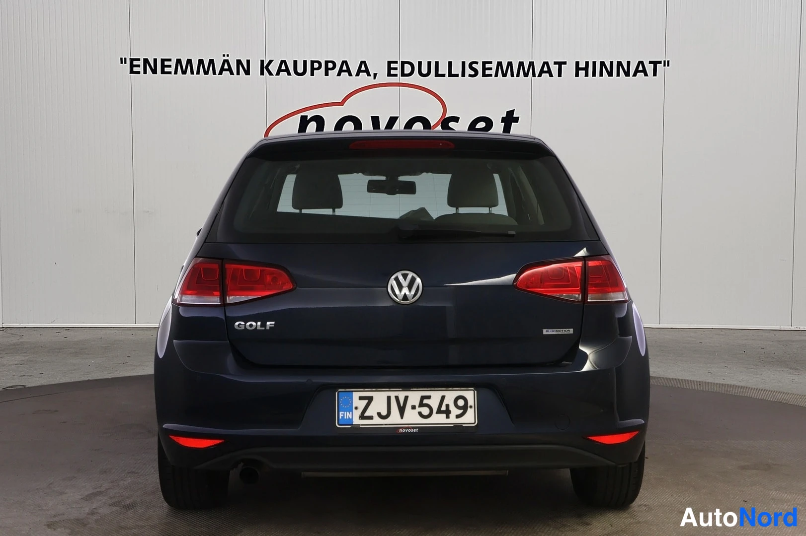 Takaa: Tummansinisen Volkswagen Golf -henkilöauton takaosa suoraan sivusta; GOLF-merkintä, VW-tunnus ja rekisteritunnus takaluukussa.