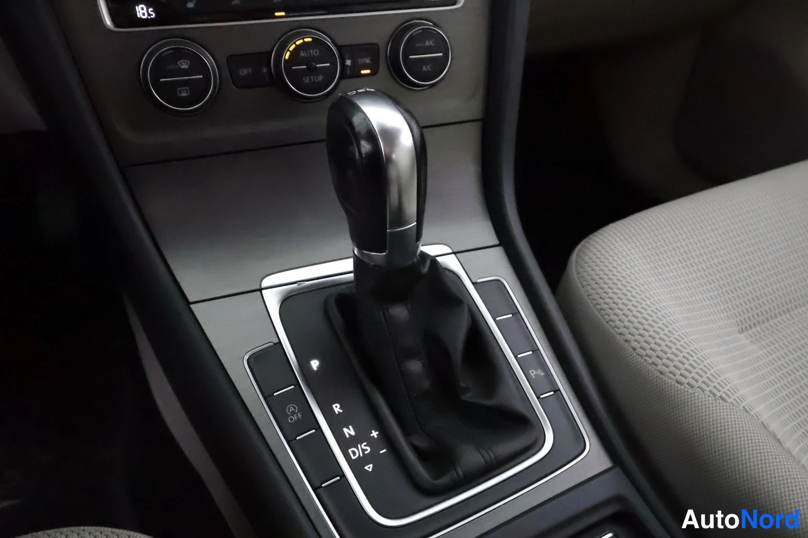Muu: Sisäkuva keskikonsolista: automaattivaihteiston valitsin (P, R, N, D/S), ilmastointiautomaation AUTO- ja SYNC-napit, istuinlämmityksen merkkivalot ja beigänrusk