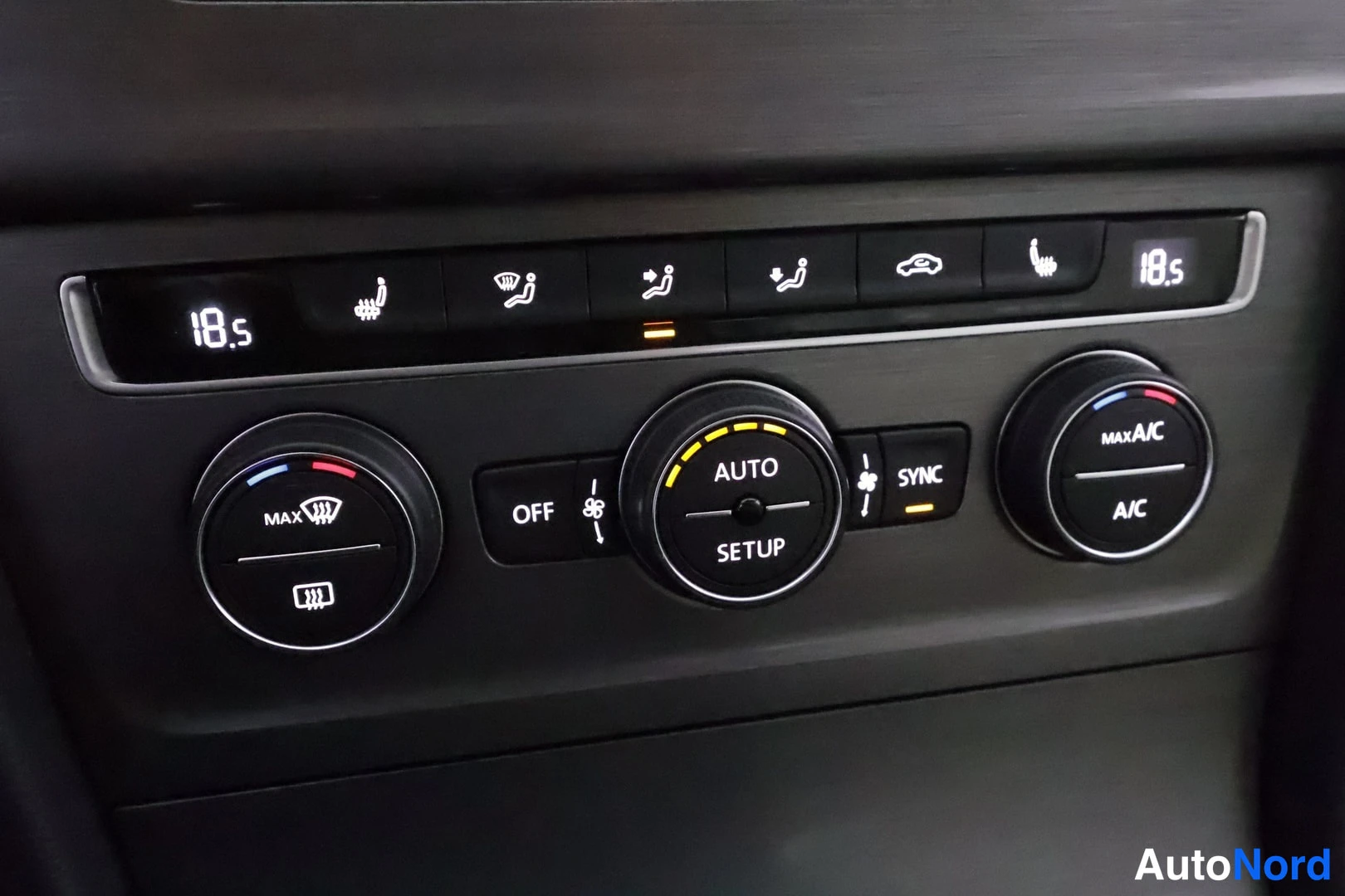 Muu: Sisäkuva ilmastointiautomaation hallintapaneelista: kaksi lämpötilanäyttöä (18,5), AUTO- ja SETUP-säädin, SYNC- ja OFF-napit, MAX A/C -nappi sekä istuinlämmitys