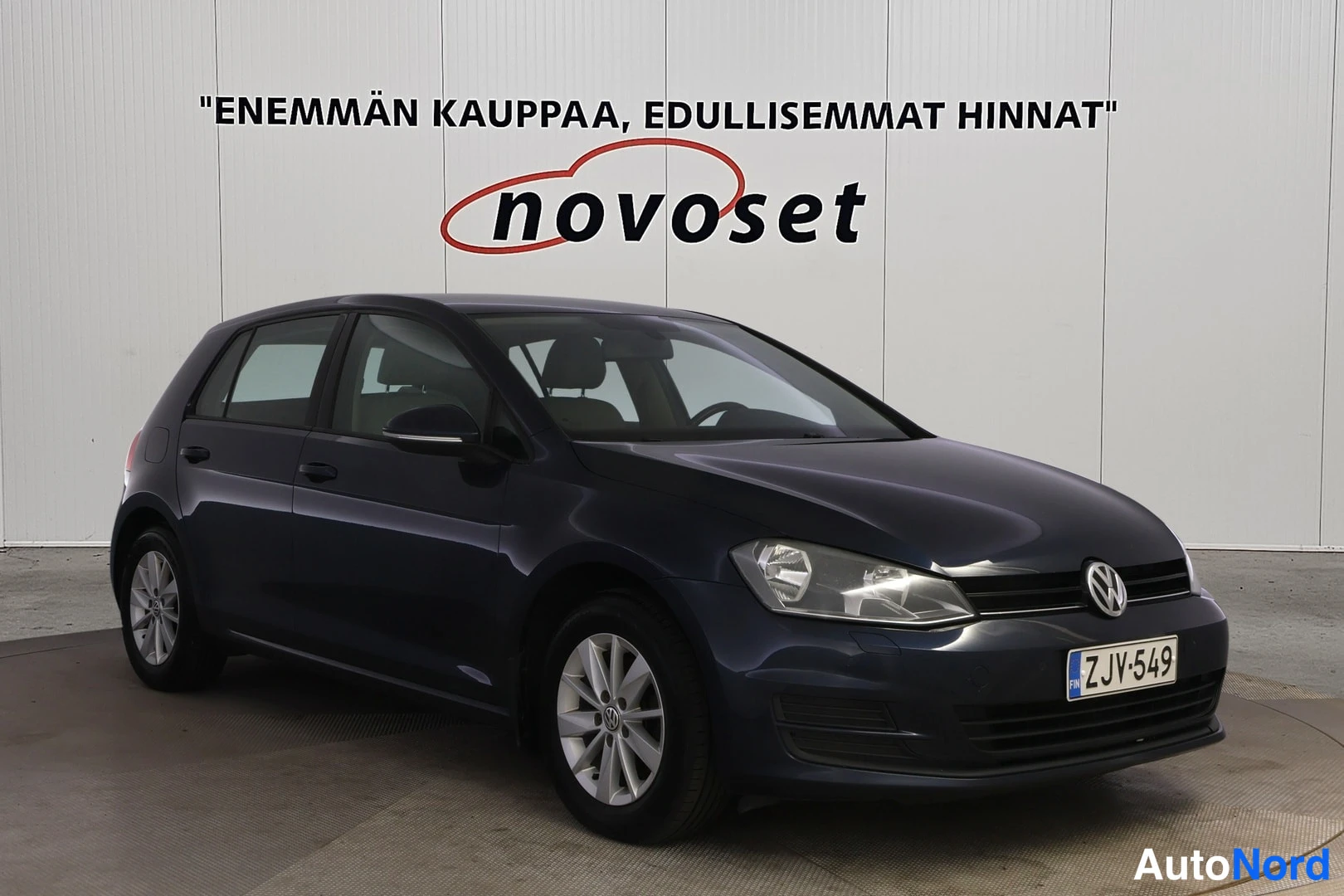 Etuviisto, nokka vasemmalle: Dark blue five-door hatchback in front three-quarter view showing grille and right flank.